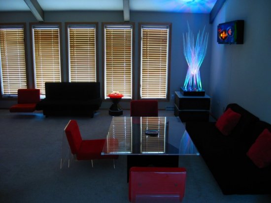 Living Dining room installation plexiglass dining table with chairs, sofas and Lumonics light sculptures.