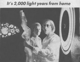 Mel Tanner holding light sculpture with Dorothy Tanner in background