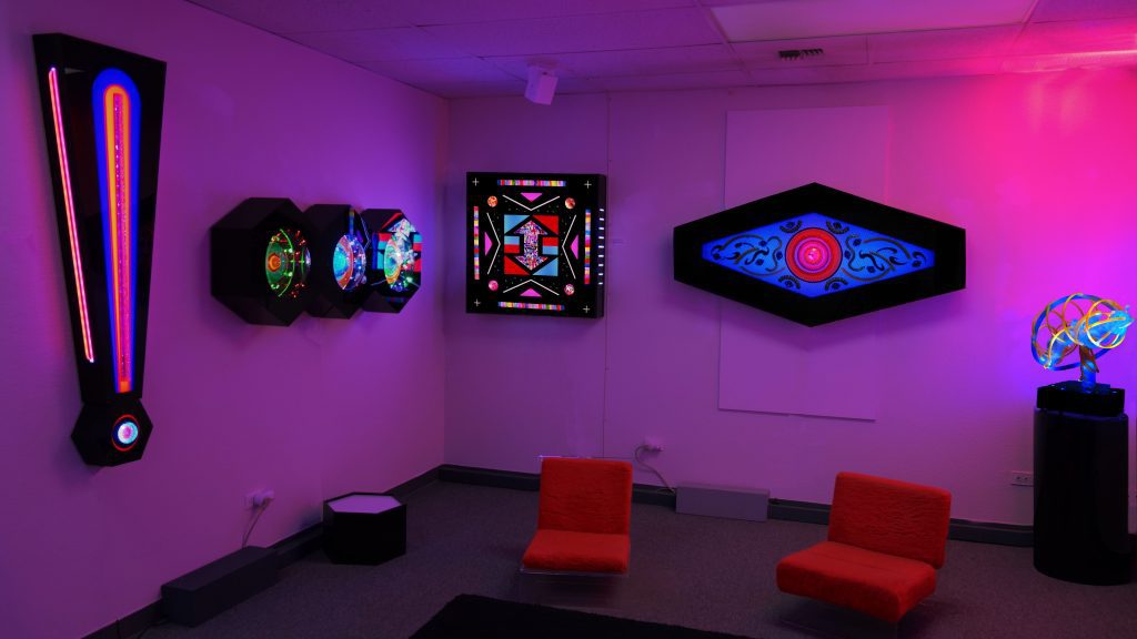 colorful wall-mounted and free-standing light sculptures and chairs in the Lumonics Light & Sound Gallery